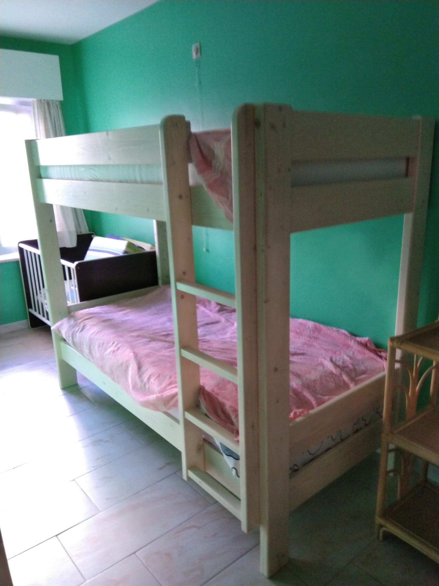 Chambre verte avec lit superposé et lit bébé