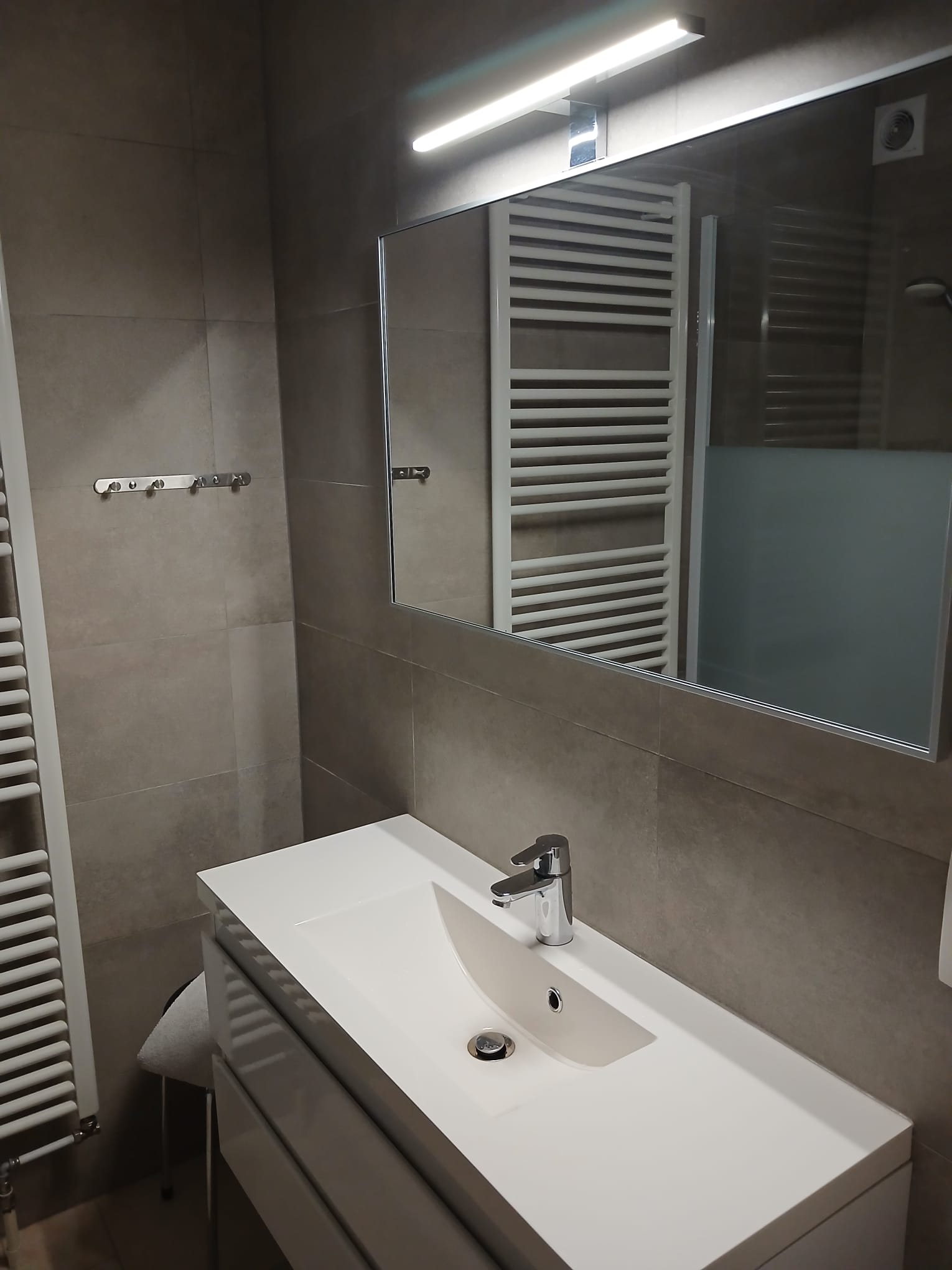 Salle de bain avec lavabo et miroir éclairé